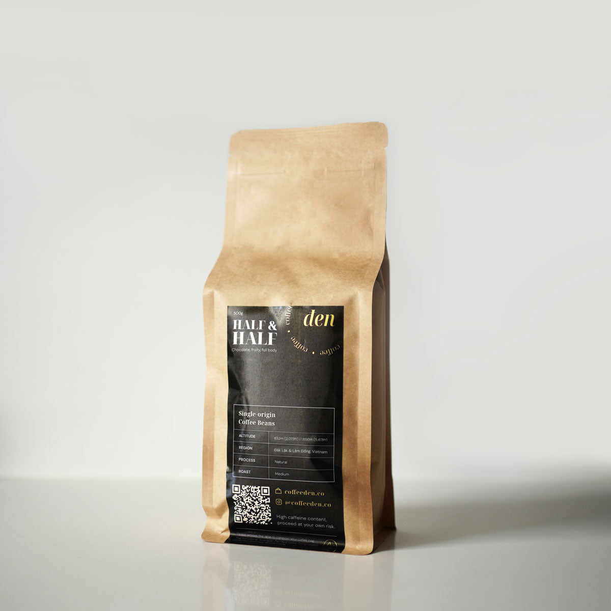 A sealed kraft bag of coffee beans labeled 'den' positioned against a white background.